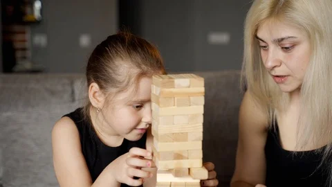 Jenga tower. Child makes her move. Slow motion Stock Footage 128422441