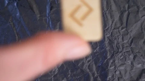Jera rune. close-up, hand puts the rune on the surface for divination. 4k, slow Stock Footage 87879871