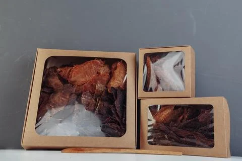 Jerky beef and spices on an old table in paper boxes Stock Photos