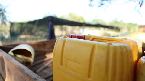 Jerry can being placed on back of truck in rural Kenya Stock Footage 138147346