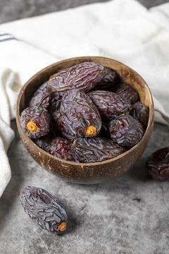 Jerusalem date fruit on stone background. Huge date fruit in a coconut bowl.  Stock Photos