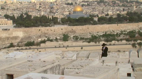 Jerusalem Mount of Olives Graveyard with a praying Jew and Old City Stock Footage 65020207