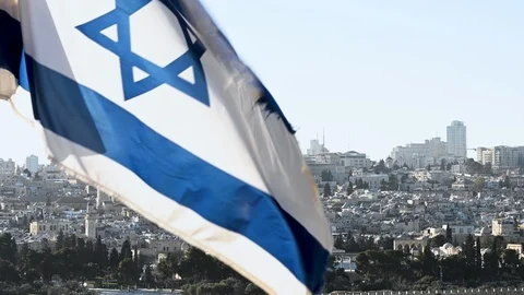 Jerusalem Old City and blurred Israeli flag waving in the foreground Stock Footage