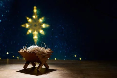 Jesus born. Empty Manger Scene. A wooden manger with straw under a glowing star Stock-Fotos