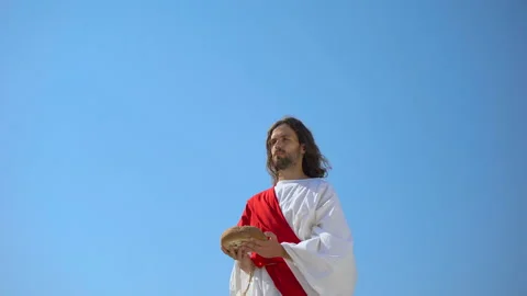 Jesus God raising bread in hands to sky, blessing sacramental food, Eucharist Stock Footage 112633812