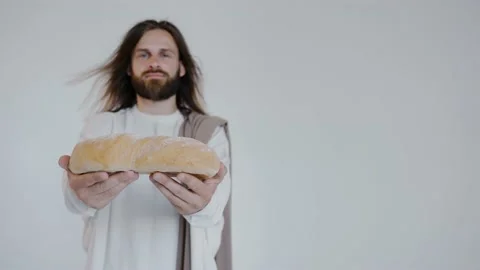Jesus is holding bread on a white background. Studio. Close up. Video stock 160494509