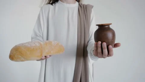 Jesus is holding a jug and bread on a white background. Studio. Close up. 스톡 동영상 160493437