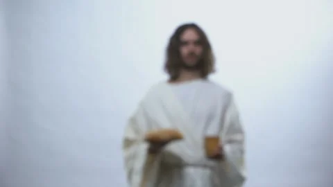 Jesus holding wine and bread on illuminated background, Christian ceremony Stock Footage 107393483