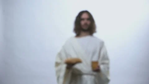 Jesus holding wine and bread on illuminated background, Christian ceremony Stock Footage 107421198
