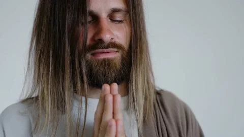 Jesus prays with his hands together on a white background. Studio. Close up. Video stock 160494792