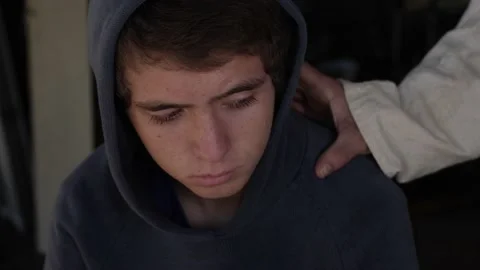 Jesus puts his hand on the shoulder of a teenage boy. The teen looks up at Stock Footage 149061915