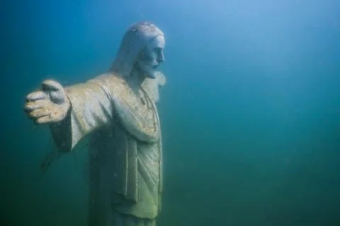 Jesus statue side view while diving in a lake Stock Photos