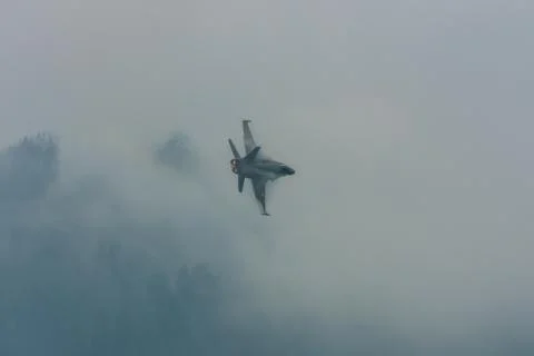 Jet accelerates in rainclouds on a air show Stock Photos