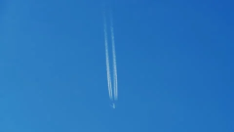 Jet airplane flying high in clear blue sky leaving contrails Stock Footage 346664431