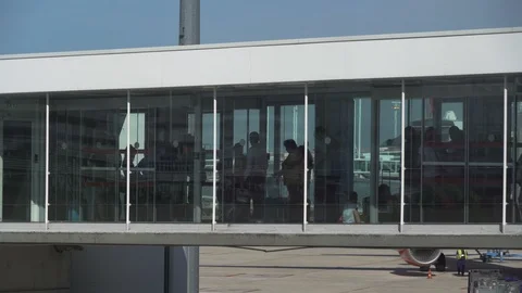 Jet bridge full of queuing travellers waiting in line to board plane Stock Footage 119821694