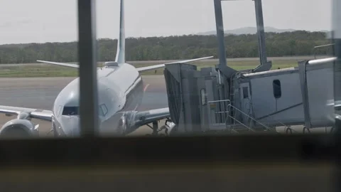Jet bridge or jetway connecting to commercial airplane at an airport gate Stock Footage 320359630