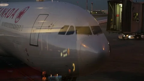 Jet Bridge or Jetway Moving Toward Air Canada Airplane with Ramp Crew Stock Footage 219227450