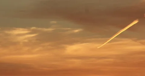 Jet creates a contrail over a sunset sky. 動画素材 133980350