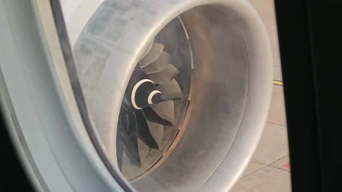Jet engine of aircraft rotating by wind looking from passenger window view. Stock Footage 238760462