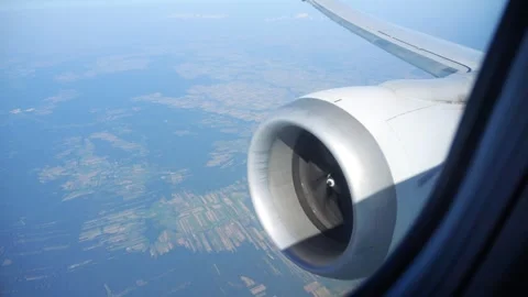Jet engine of an airplane mid-flight with views of the landscape below in 4.. Stock-Footage 284218999