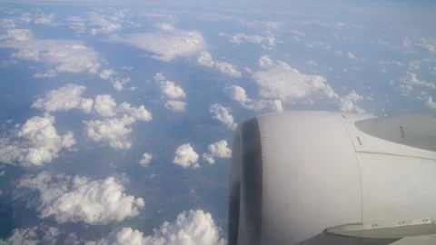 Jet Engine and Fluffy Clouds From Airplane at Cruising Altitude During Daylight Stock Footage 314101482