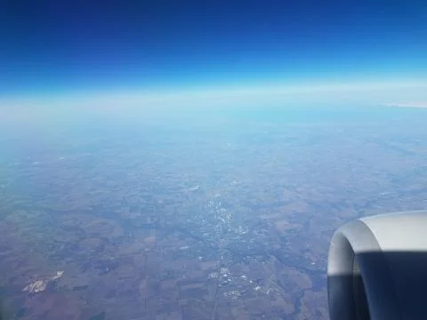 Jet engine and ground seen from airplane window Stock Photos
