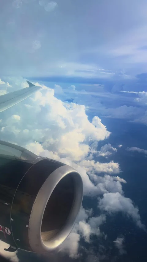 Jet Engine and Wing View Above Dramatic Cumulus Cloud Formations in Blue Sky. Stock Footage 338360470