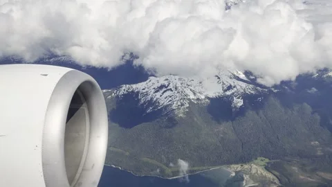 Jet engine cowling frames snowy peaks and a braided delta over a deep blue fjord Stock Footage 336218996