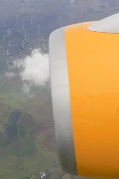 A jet engine on a plane, flying over a wind farm in the southern uplands of S Stock Photos