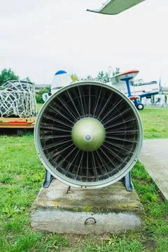 Jet engine sits on a concrete pad at an outdoor aviation display in the day.. Stock Photos