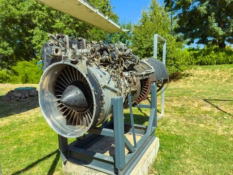 A jet engine sits on a stand in an outdoor museum. The sun is shining bright, Stock Photos