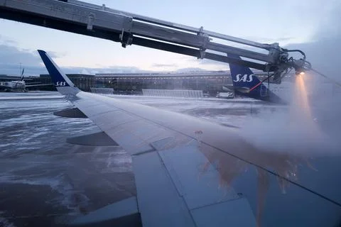 A jet engine is spraying de-icing on the wing of a plane Foto stock