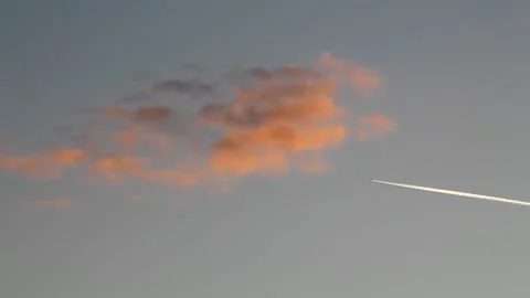 Jet flight with clouds in the evening light. Jet vapor trail. Stock Footage 143496999