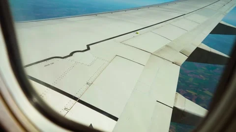 Jet flying above colorful patchwork of fields, view from window porthole. Plane Stock Footage 317543446