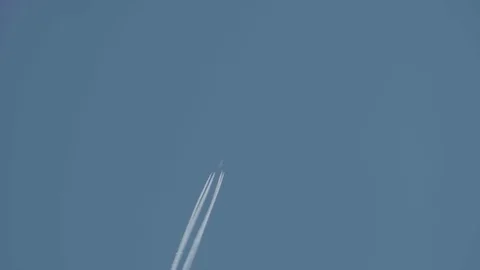 Jet flying at high altitude leaving behind four streaks of condensatio Stock Footage 70698117