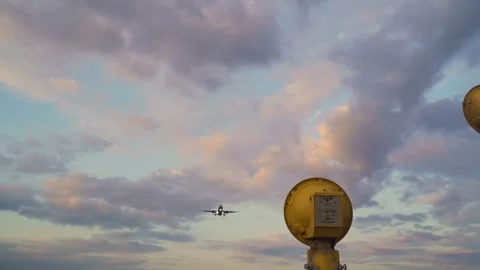 Jet flying overhead in evening clouds sky. Airplane landing in slow motion Stock-Footage 117376171
