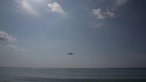 Jet Liner Passes Overhead of People on Beach Stock Footage 85345169