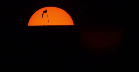 Jet passing in front of sun and Silhouette of wind sock Stock Footage 67337464