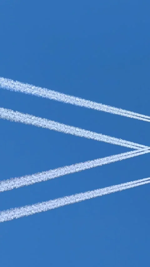 A jet plane creates a white trail across the blue sky, forming a striking geo Stock Footage 301866487