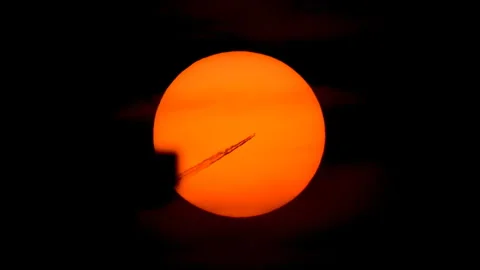 Jet plane crossing a vivid orange sun Stock Footage 342571017