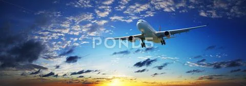 Jet plane in a sunset sky. panoramic composition in high resolution. Stock Photos