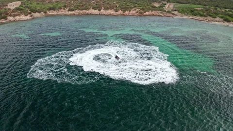 Jet ski creates swirling patterns in the turquoise waters near Sardinia Stock Footage 280474355