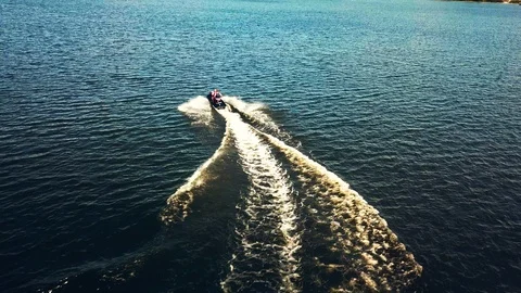 A jet ski cuts through waves at speed. Jet ski on the river in sunny weather Stock Footage 128004827