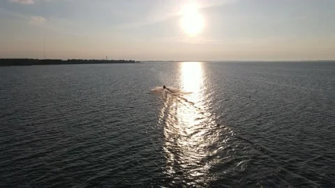 Jet ski driving through lake Erie at sunset 動画素材 133351271