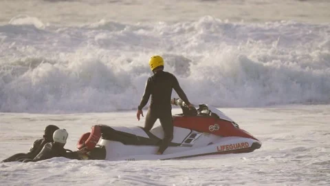 Jet ski lifeguard drags two survivors slow motion Stock Footage 146249941