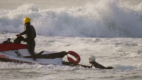 Jet ski lifeguard saving surfer in crashing ocean waters slow motion Stock Footage 146249779