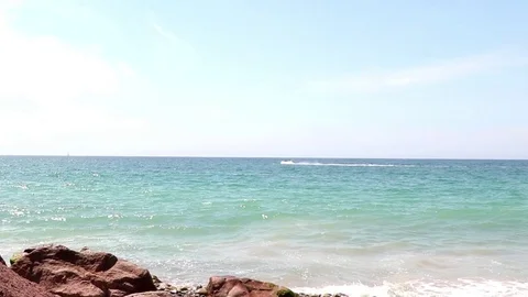 Jet ski in the ocean, crossing frame, rocks in foreground Stock Footage 78009405