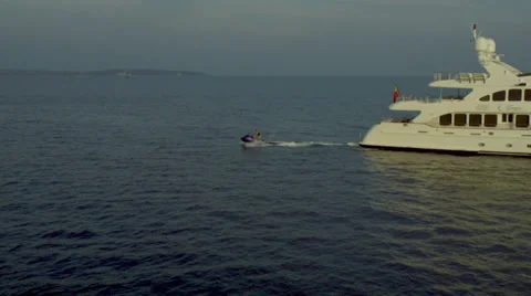 Jet Ski Pulling Away From Back of Yacht - Helicopter Shot Vídeo Stock 39700923