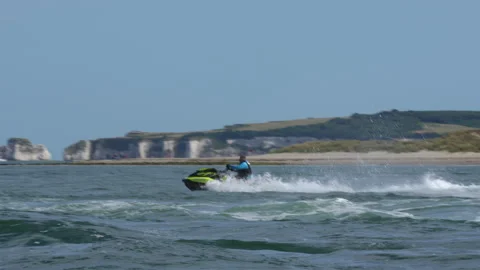 Jet Ski Wave Jumping Bouncing over rough sea in Bournemouth Sand Banks Stock Footage 246420234