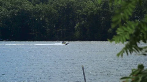 Jet Skiing on Lake During Cloudy Summer Day 動画素材 65964716
